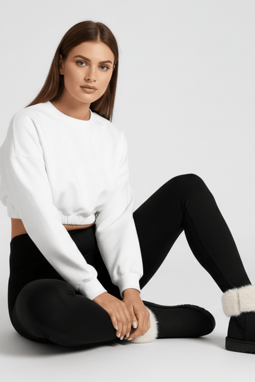 Seated casual pose, woman wearing black CozyTherm™ leggings H#color_black